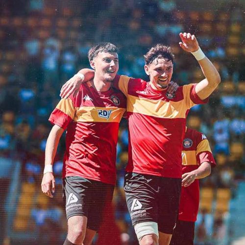 Two Racing Club de Calais players celebrating together on the pitch
